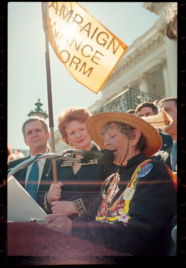 Granny D, a then 91 year old grandmother with a wicker hat, speaking at a podium